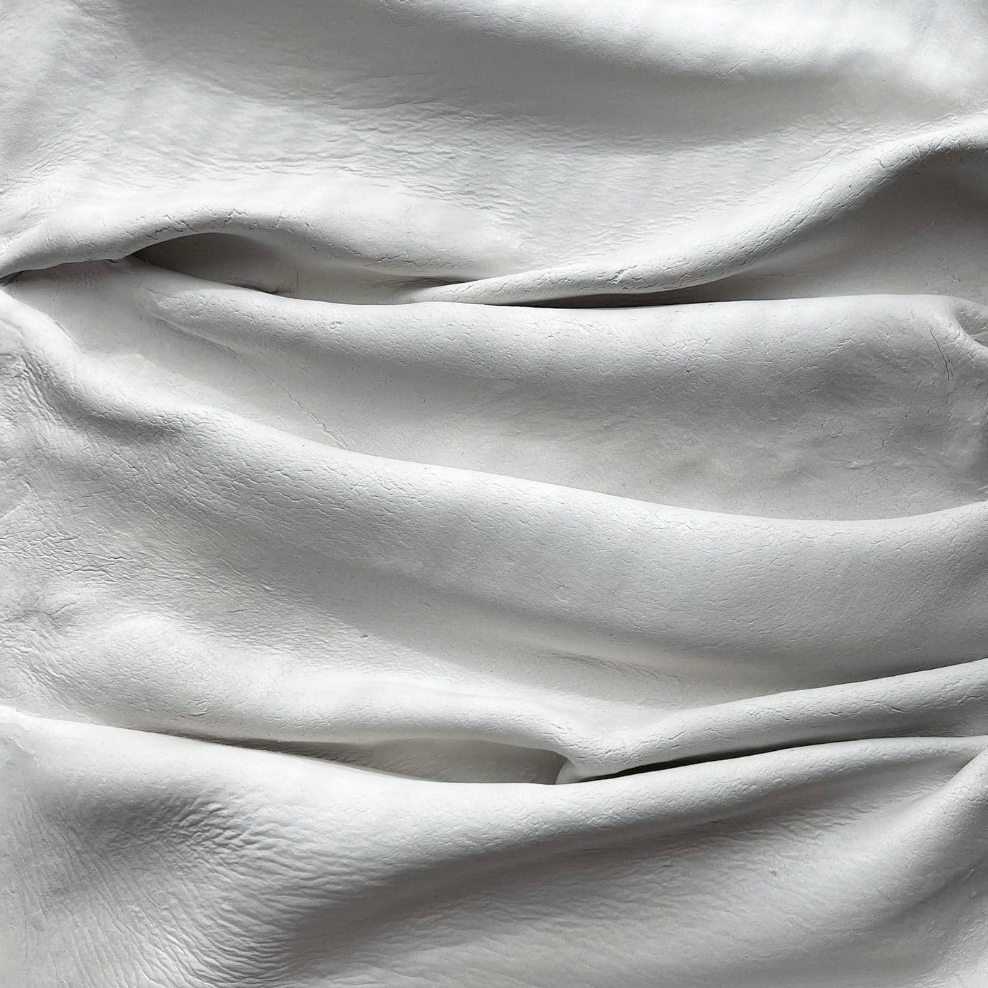 Soft folds of white fabric in daylight